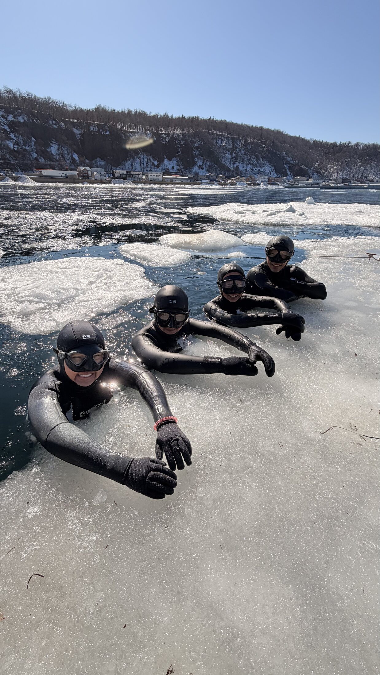 流氷の穴から顔を出す参加者たち