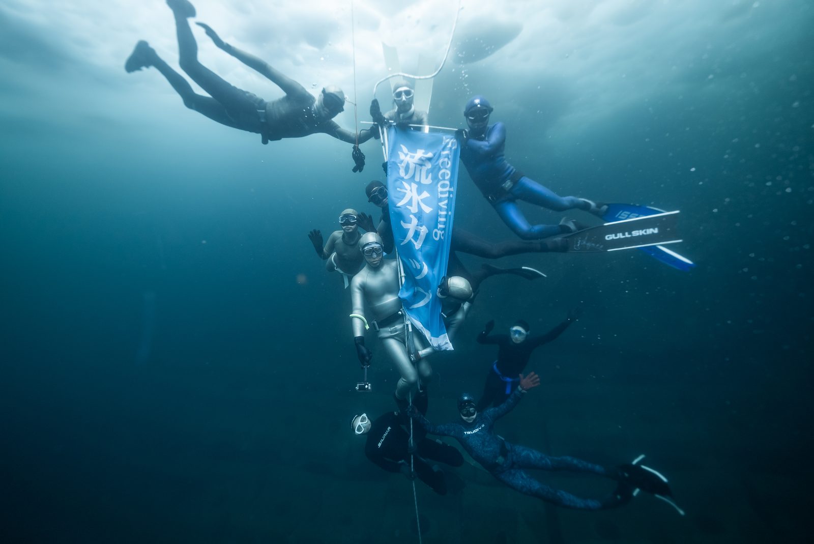 流氷カップの旗と水中のフリーダイバーたち