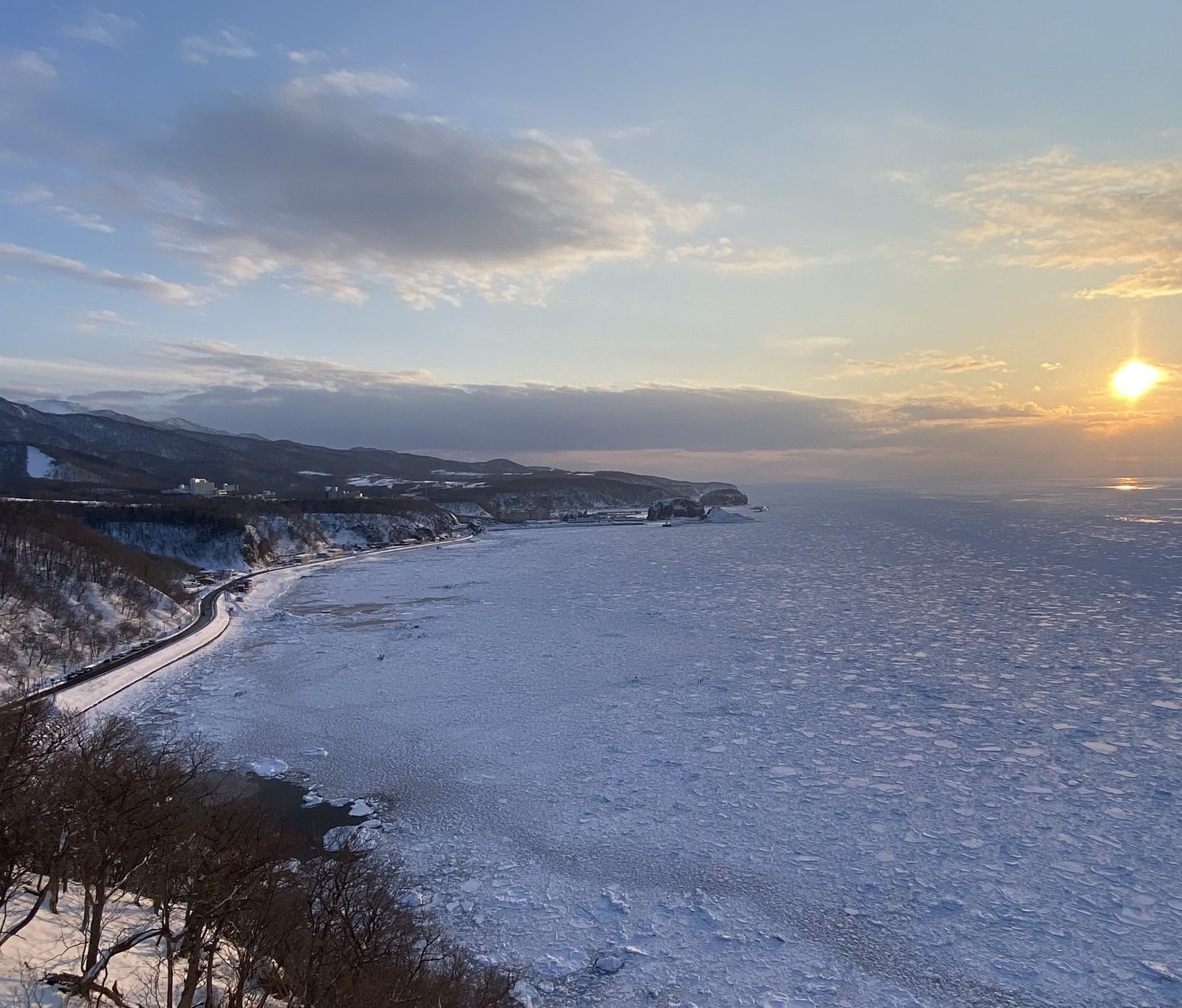 高台から望むウトロ湾の流氷と夕日